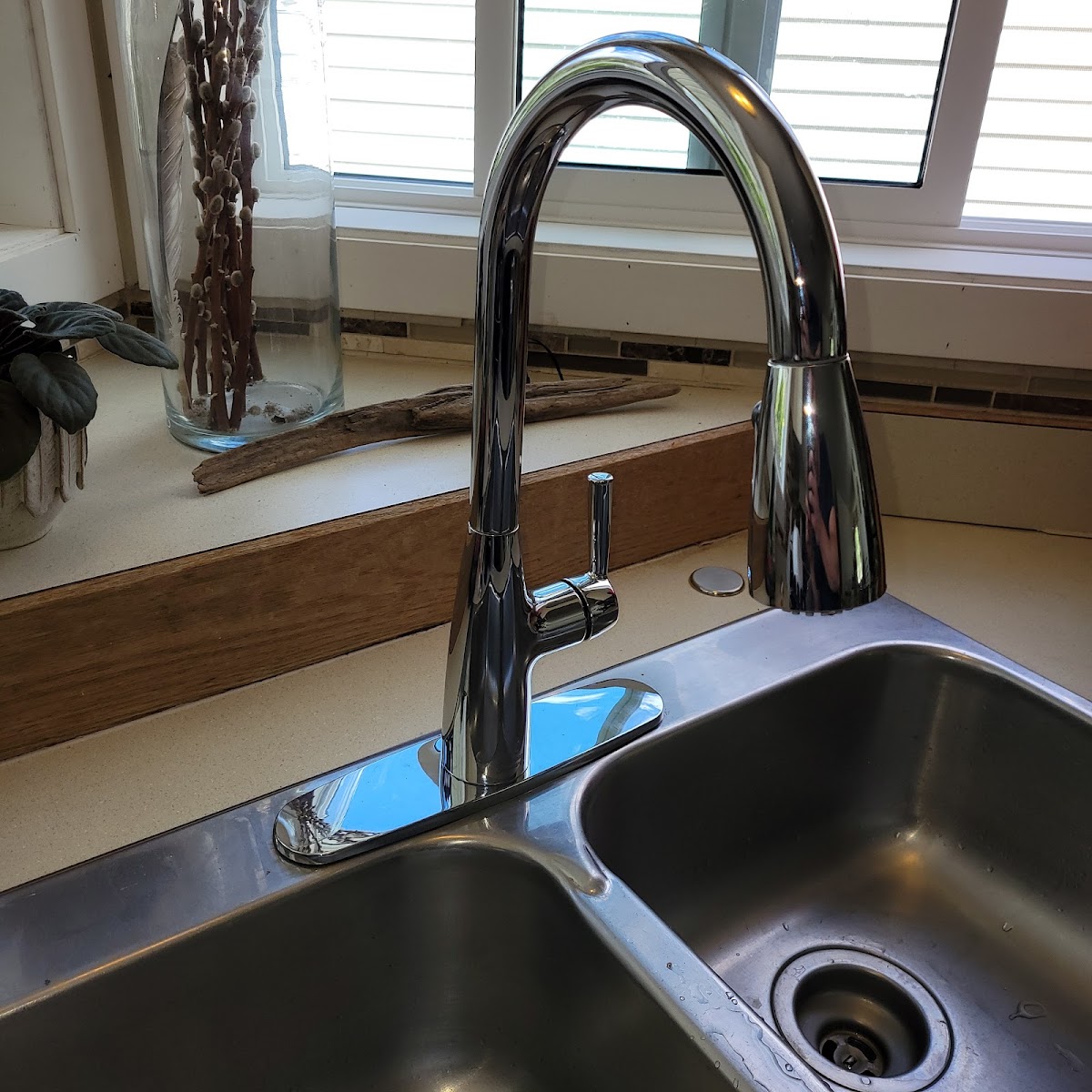 Chrome pull-down kitchen faucet over a stainless undermount sink